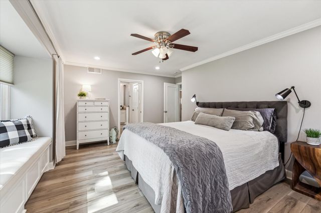 a spacious bedroom with a bed and ceiling fan