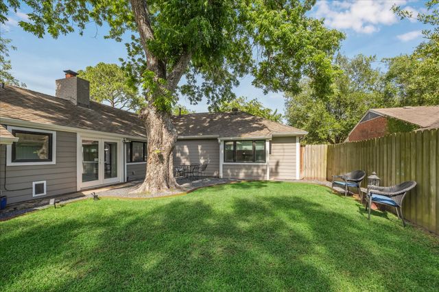 a view of a chair and table in backyard of the house