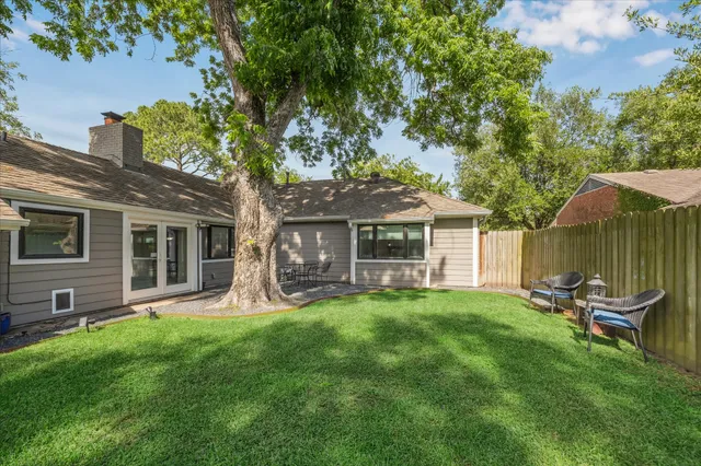 a view of a chair and table in backyard of the house