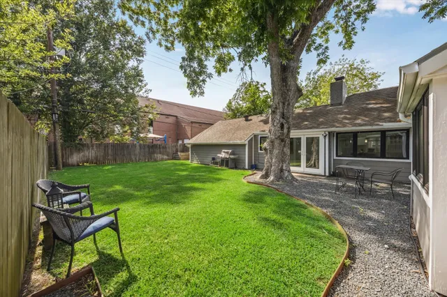 a view of a chair and table in backyard of the house