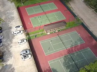 a view of a tennis court with a small white house