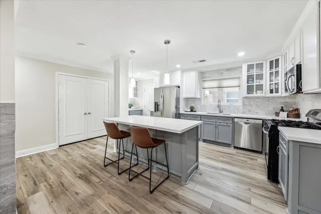 a kitchen with stainless steel appliances granite countertop a table chairs sink refrigerator and cabinets