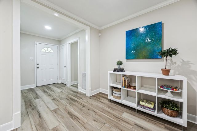 a view of an empty room with shelves and wooden floor