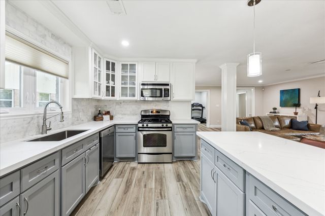 a kitchen with a sink a counter top space stainless steel appliances and a window