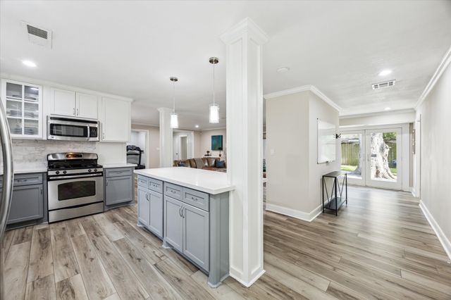 a kitchen with white cabinets and stainless steel appliances