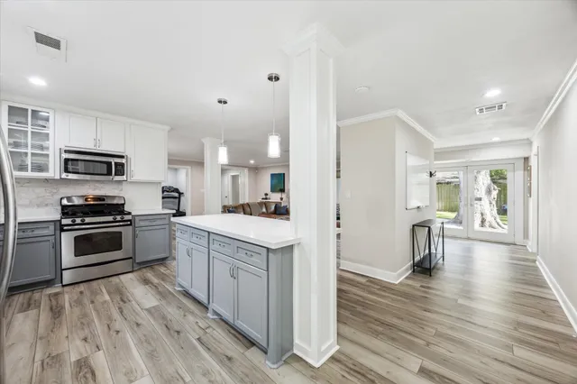 a kitchen with white cabinets and stainless steel appliances