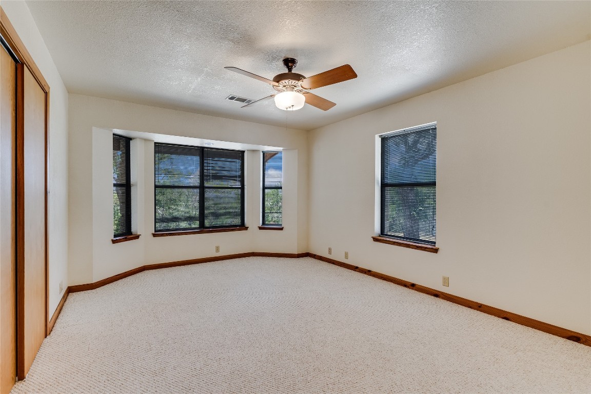 199 Middleton Road Spicewood, TX 78669 - Photo 18 of 39 an empty room with windows and fan