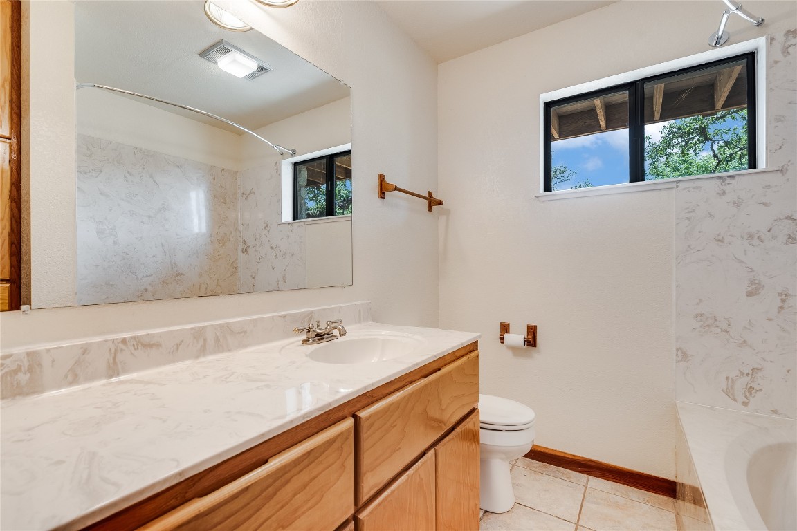 199 Middleton Road Spicewood, TX 78669 - Photo 20 of 39 a bathroom with a sink a toilet and shower