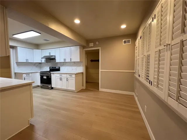 a large kitchen with stainless steel appliances granite countertop a refrigerator and a stove top oven