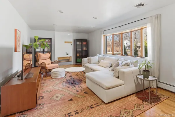 a living room with furniture a flat screen tv and a table