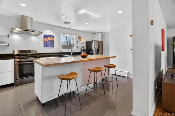a large kitchen with stainless steel appliances granite countertop a large stove a sink dishwasher and cabinets with wooden floor