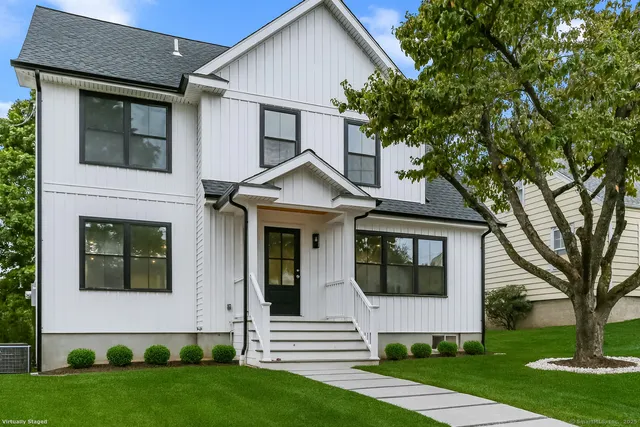 a front view of a house with a yard and trees