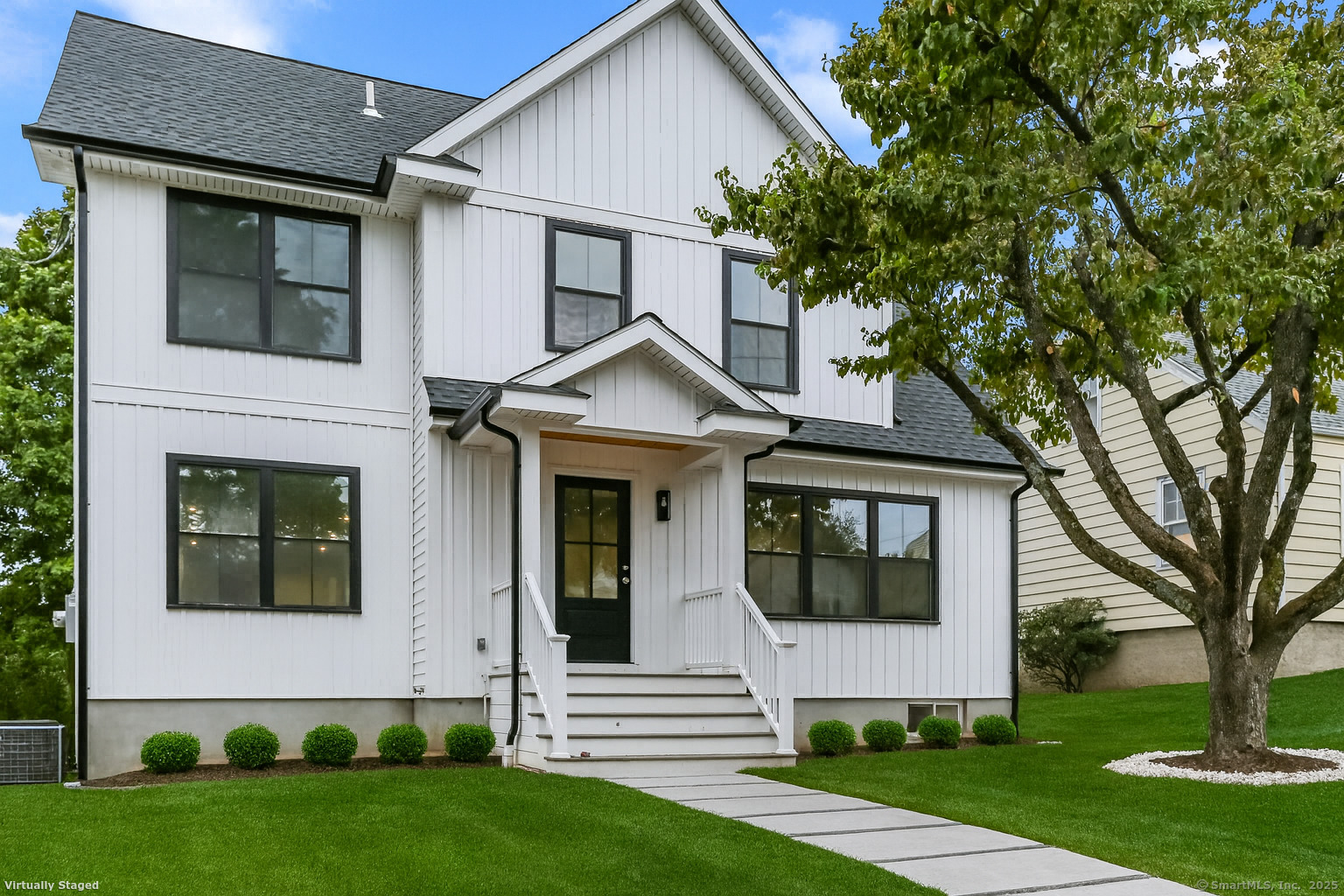 a front view of a house with a yard and trees