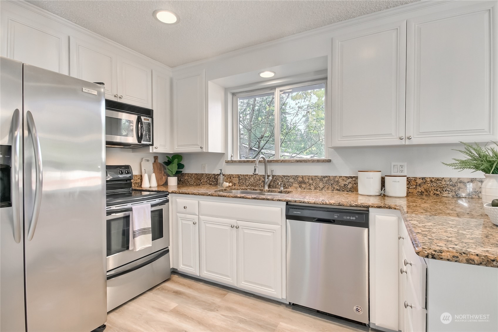 19818 34th Drive Southeast Bothell, WA 98012 - Photo 13 of 34 a kitchen with granite countertop white cabinets and stainless steel appliances
