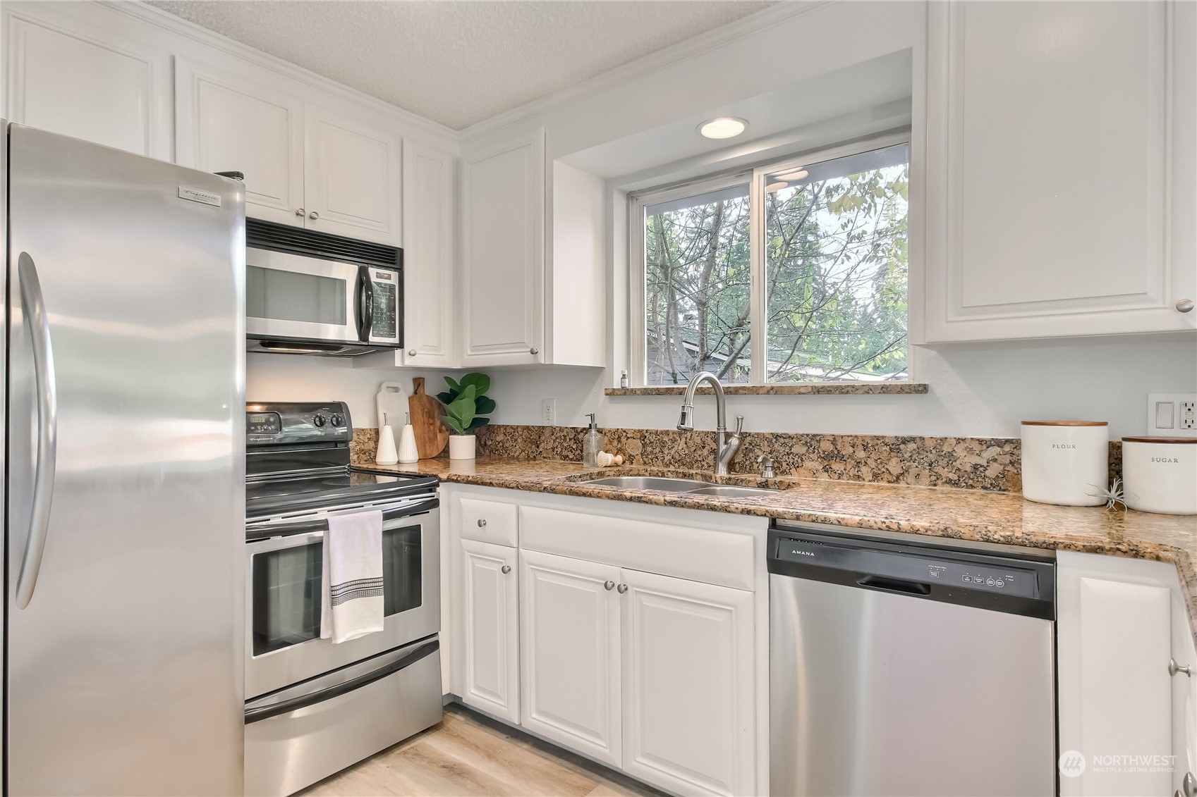 19818 34th Drive Southeast Bothell, WA 98012 - Photo 14 of 34 a kitchen with granite countertop stainless steel appliances white cabinets and a window