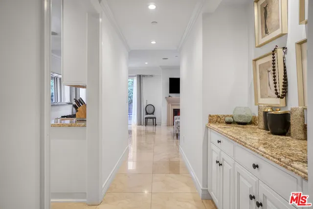 a hallway with white cabinets and chandelier