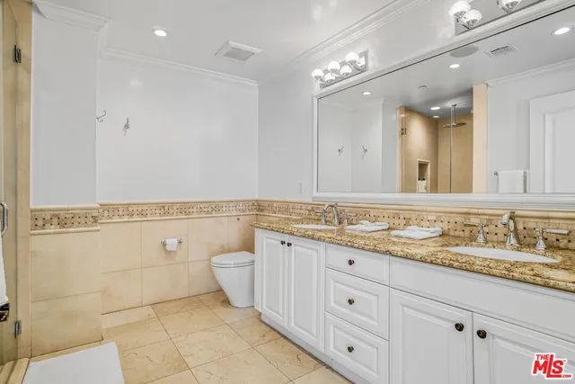 a bathroom with a granite countertop double vanity sink a mirror and a bathtub