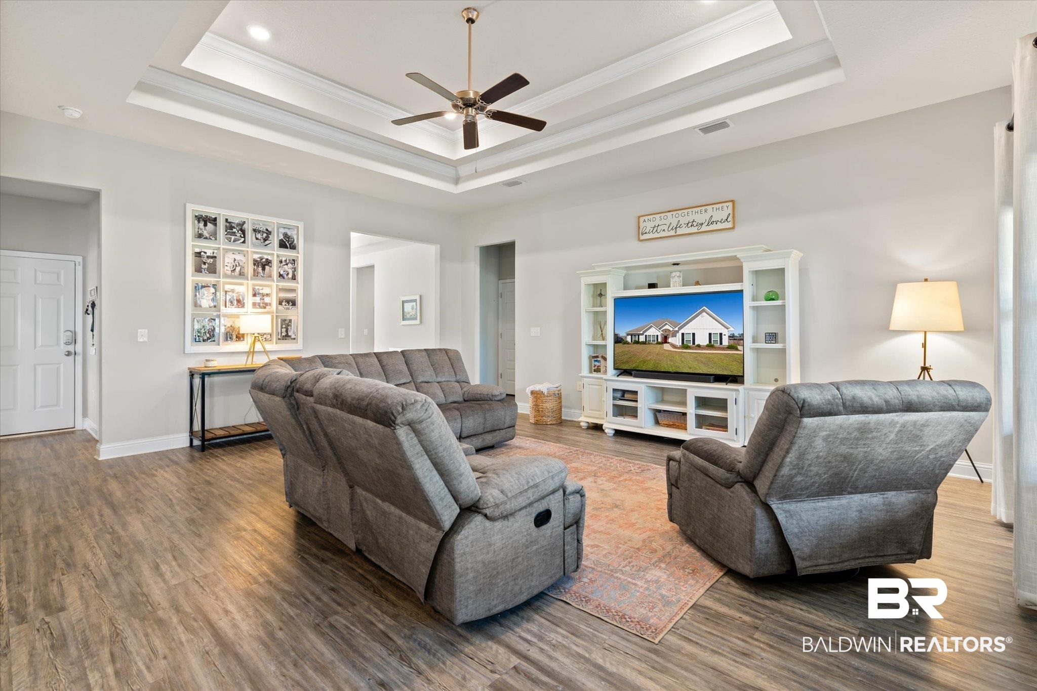 12899 Sanderling Loop Daphne, AL 36527 - Photo 8 of 28 Living room featuring ornamental molding, ceiling fan, a tray ceiling, and dark hardwood / wood-style flooring