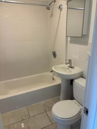 a white toilet sitting next to a bath tub