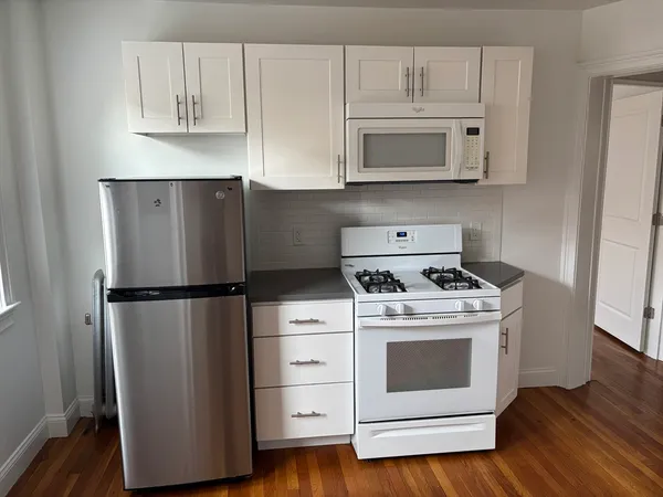 a kitchen with a stove top oven and refrigerator