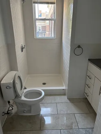 a bathroom with a granite countertop toilet and a sink