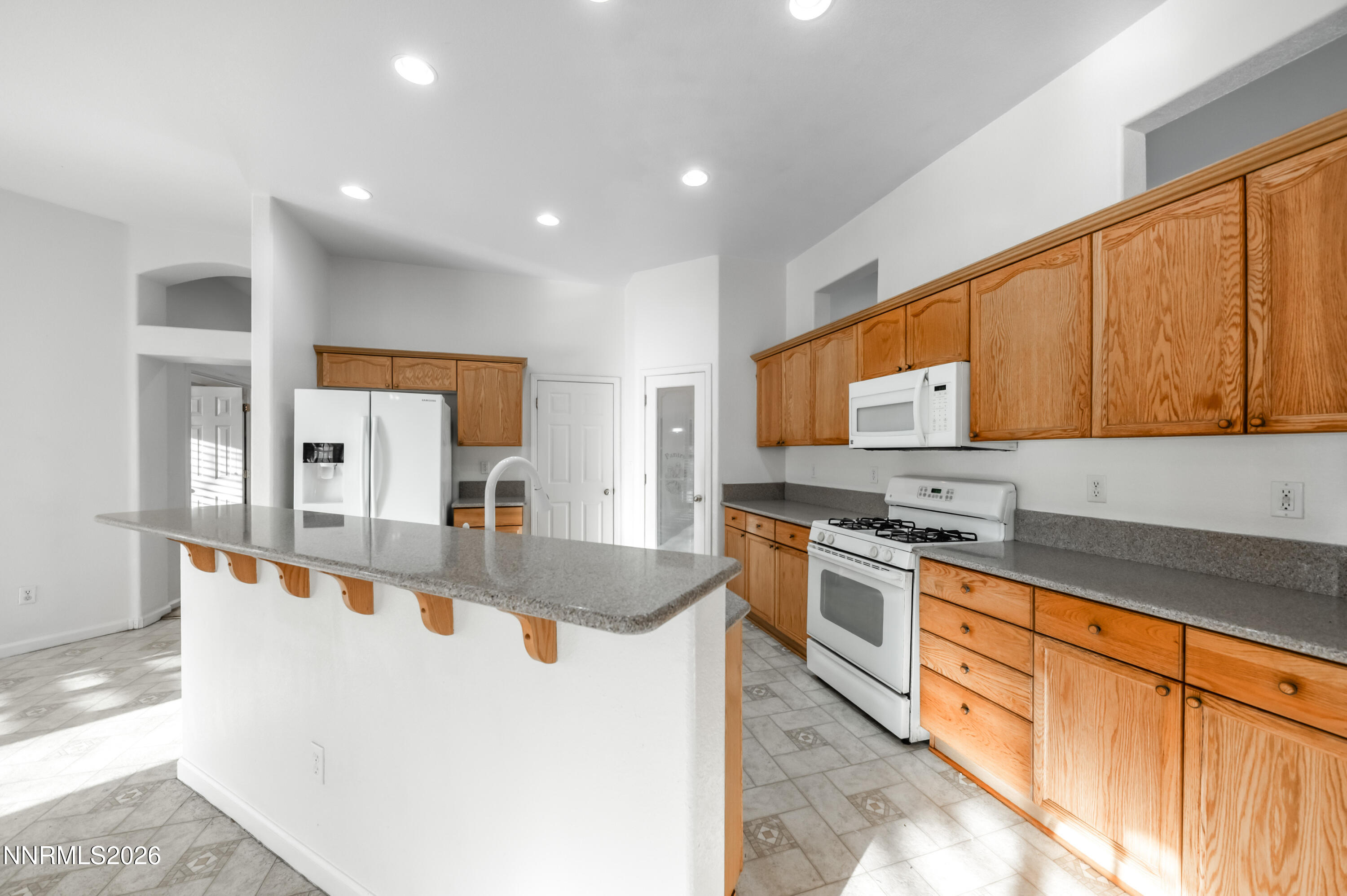 10145 Lucente Way Reno, NV 89521 - Photo 17 of 54 a large kitchen with stainless steel appliances granite countertop a stove a sink and a microwave