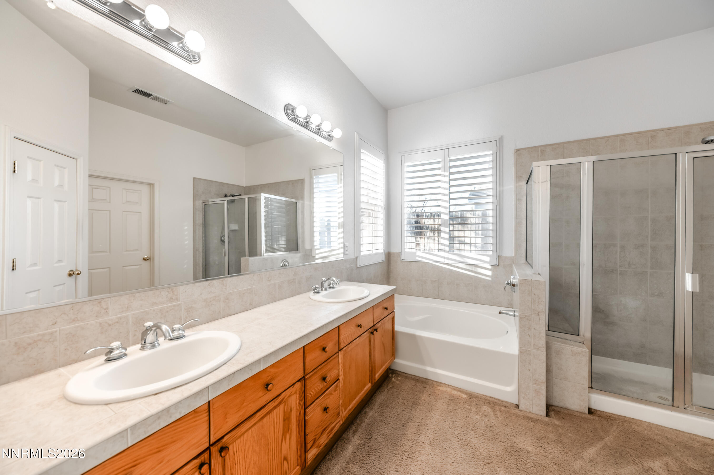 10145 Lucente Way Reno, NV 89521 - Photo 28 of 54 a spacious bathroom with double vanity a tub mirror and double