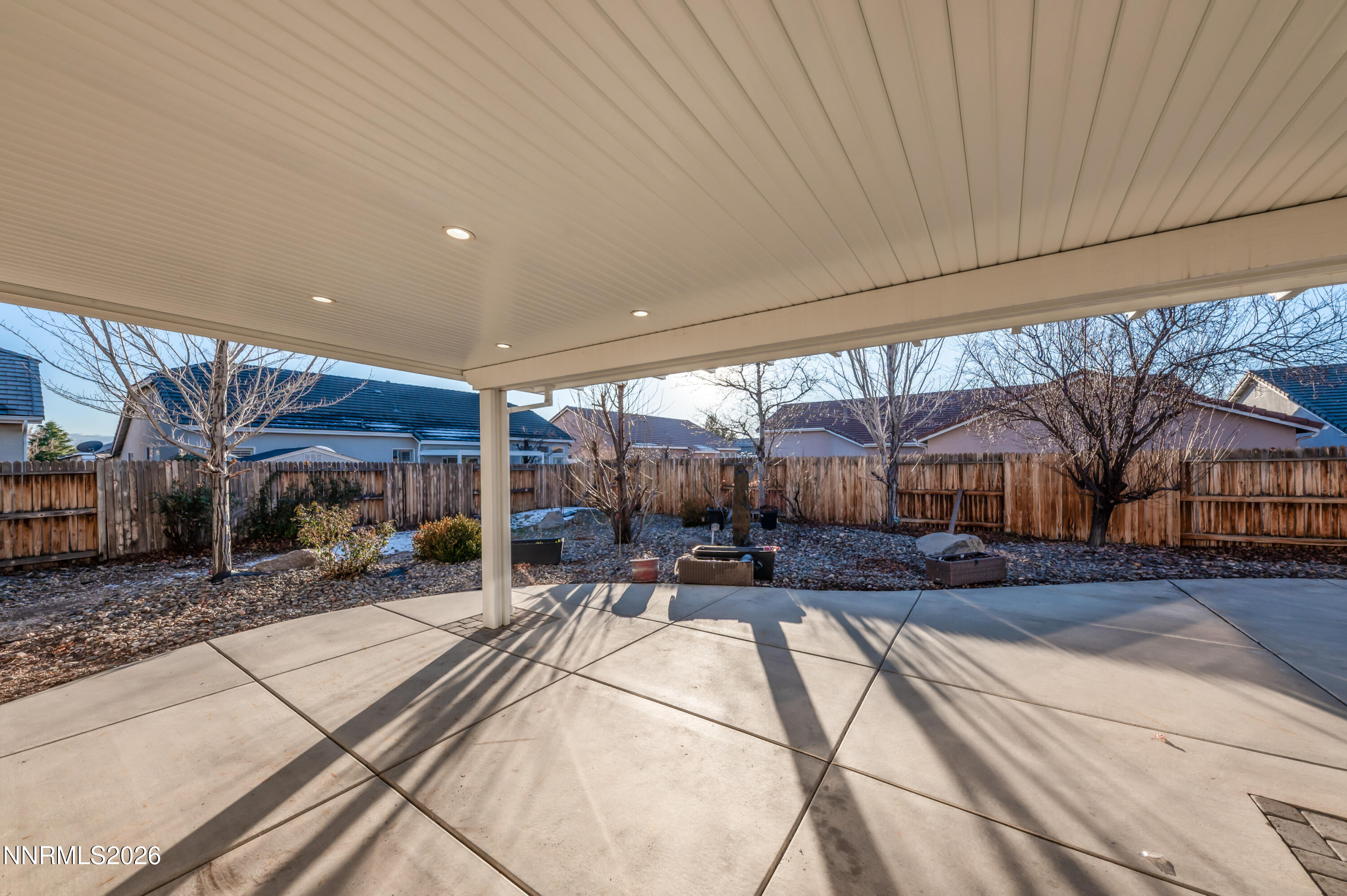 10145 Lucente Way Reno, NV 89521 - Photo 37 of 54 a view of a patio with a table and chairs under an umbrella with a large tree