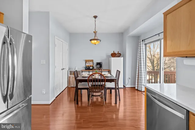 a dining room with furniture a chandelier and wooden floor