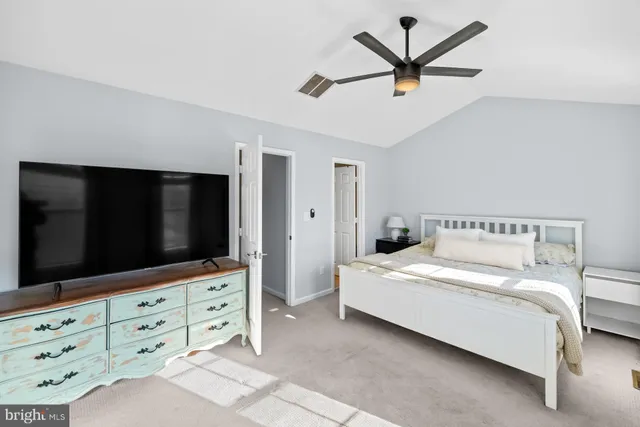 a bedroom with a bed window and a flat screen tv