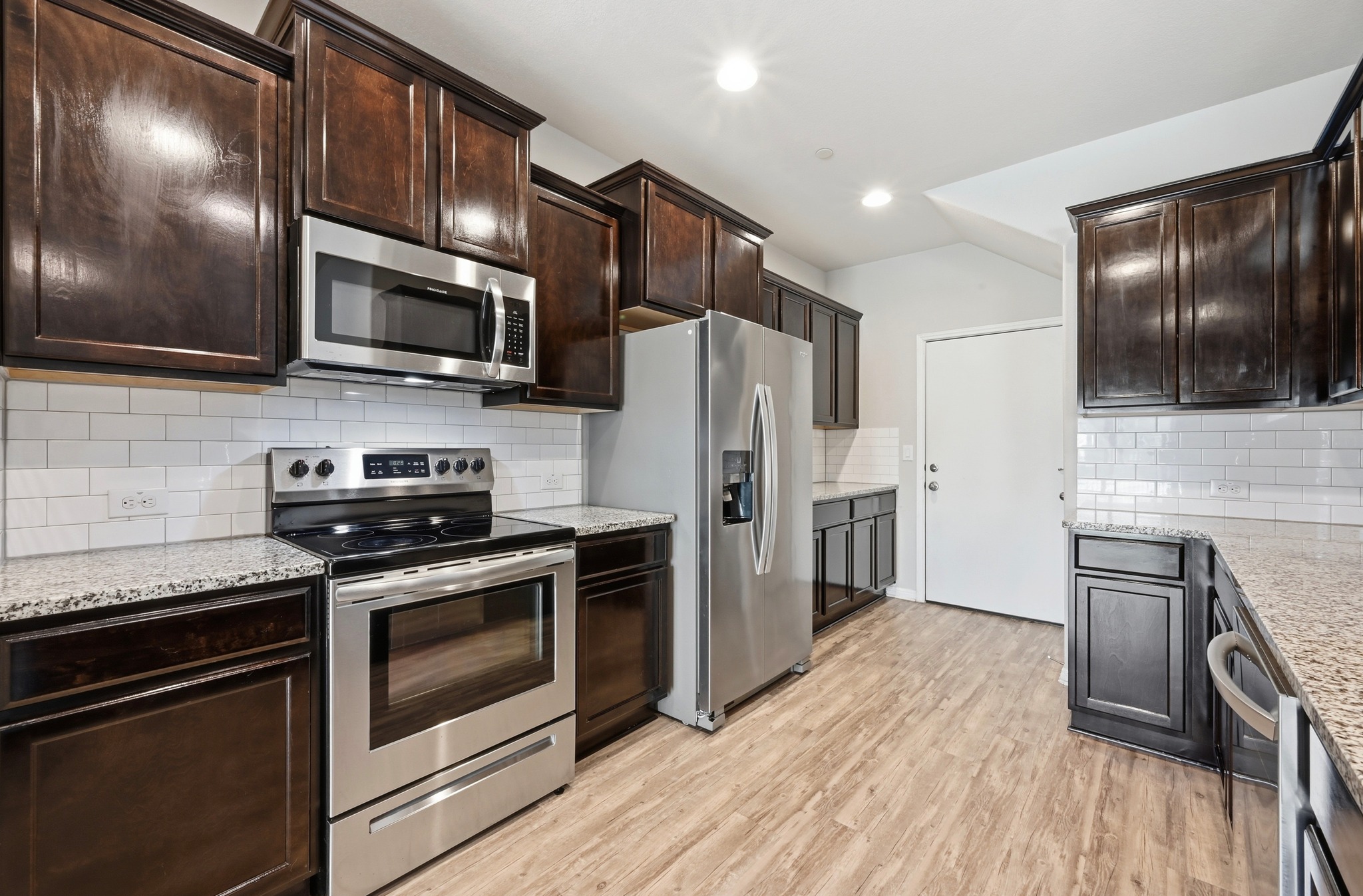 516 East Slaughter Lane, Unit 603 Austin, TX 78744 - Photo 11 of 26 a kitchen with stainless steel appliances a stove microwave and refrigerator