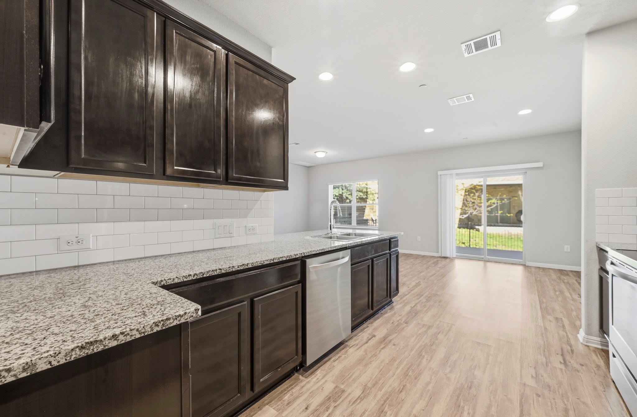 516 East Slaughter Lane, Unit 603 Austin, TX 78744 - Photo 12 of 26 a kitchen with granite countertop stainless steel appliances and wooden cabinets