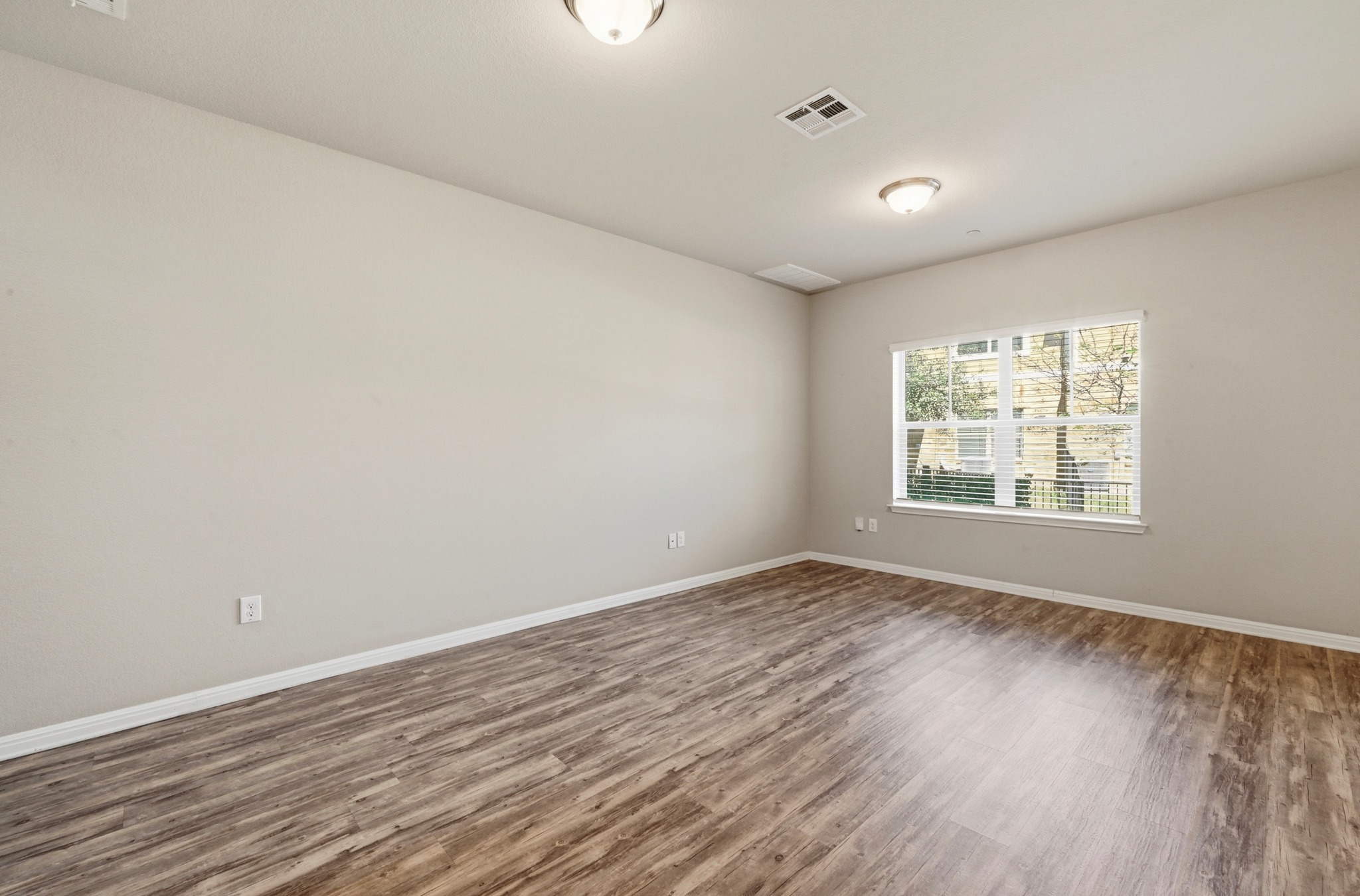 516 East Slaughter Lane, Unit 603 Austin, TX 78744 - Photo 6 of 26 wooden floor in an empty room with a window