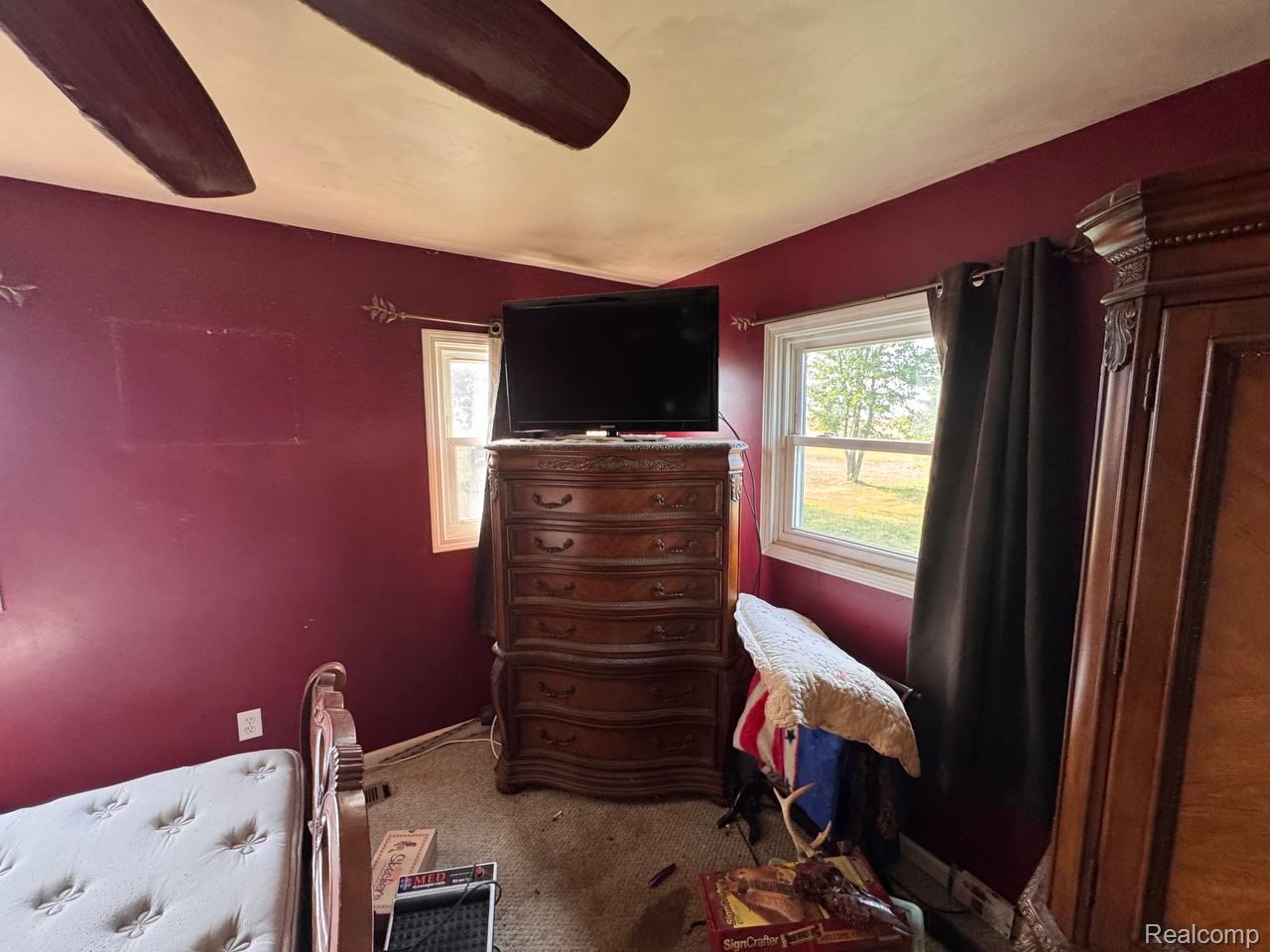 4703 North Byron Road Lennon, MI 48449 - Photo 16 of 25 Room featuring a ceiling fan, two windows, and dark red walls