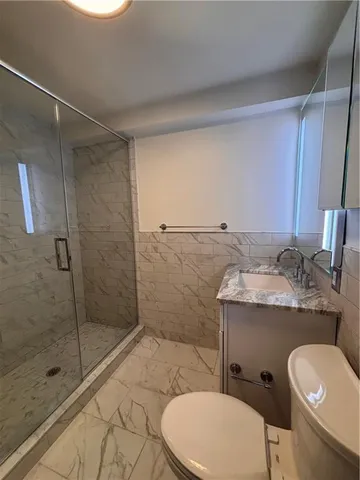 a bathroom with a granite countertop toilet sink and shower