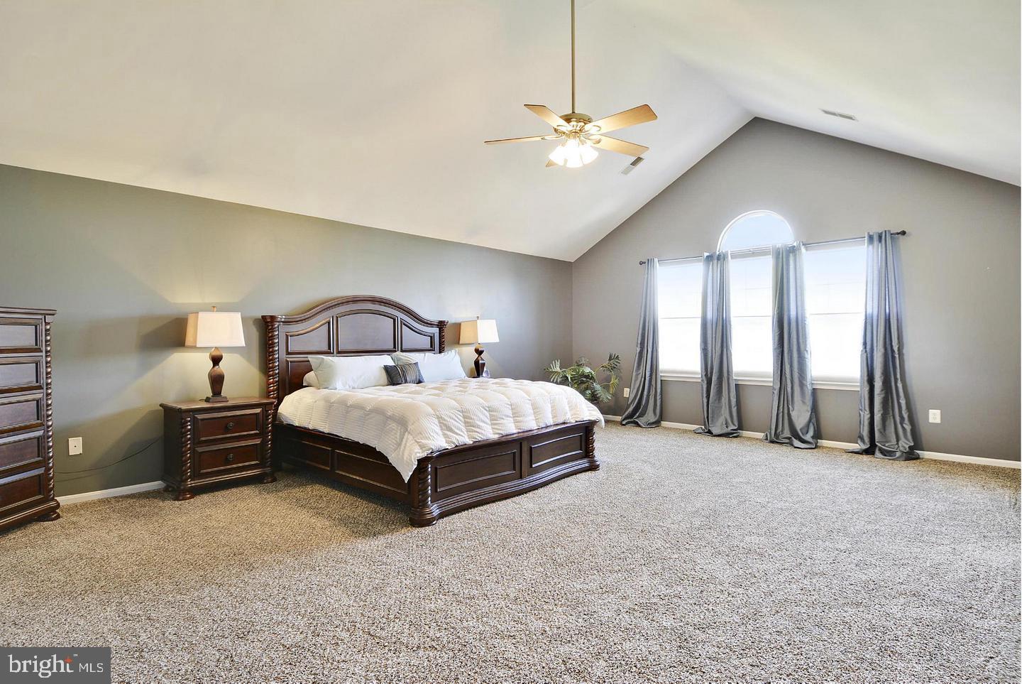 302 Riding Trail Court Northwest Leesburg, VA 20176 - Photo 9 of 15 a spacious bedroom with a bed and a chandelier