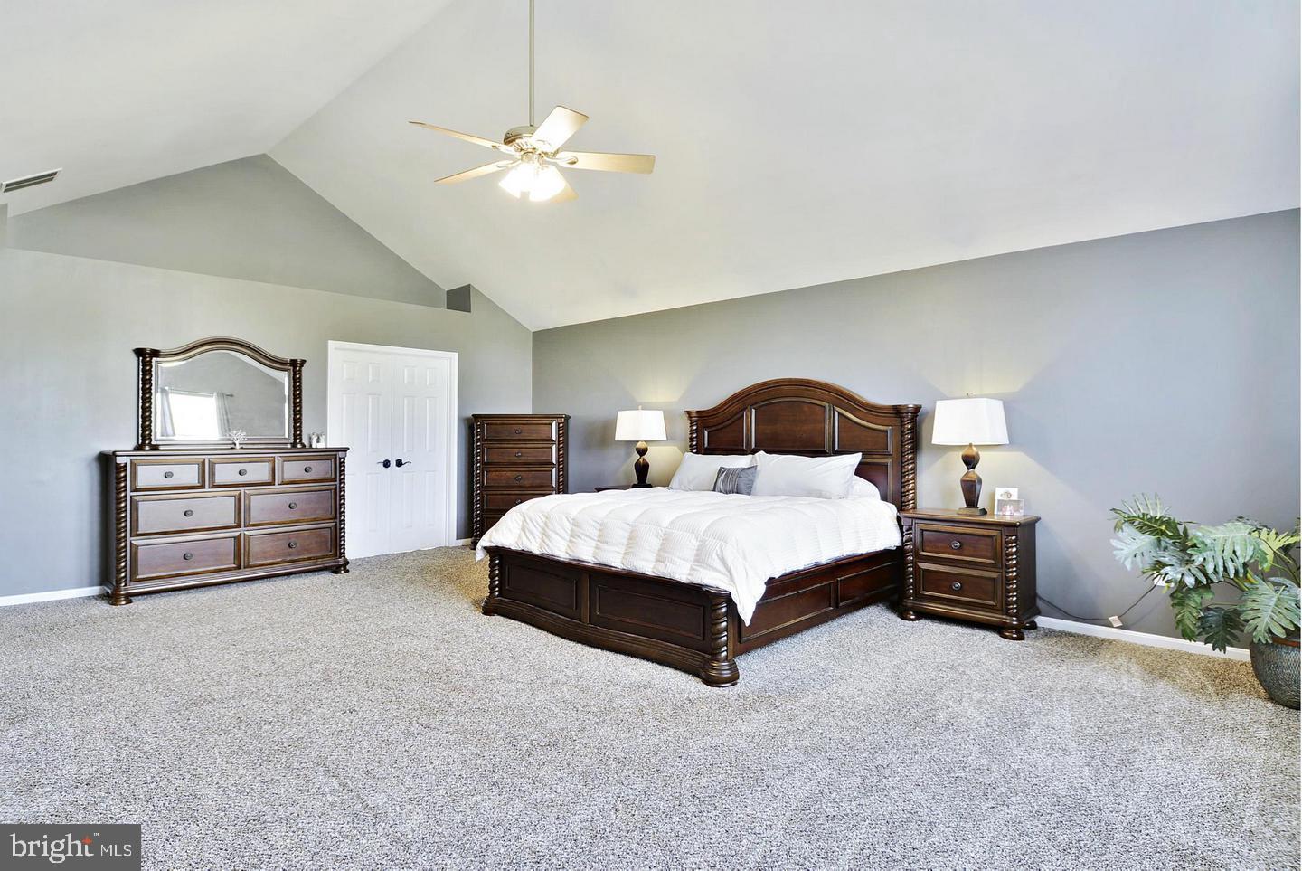 302 Riding Trail Court Northwest Leesburg, VA 20176 - Photo 10 of 15 a bedroom with a bed cabinets and a chandelier