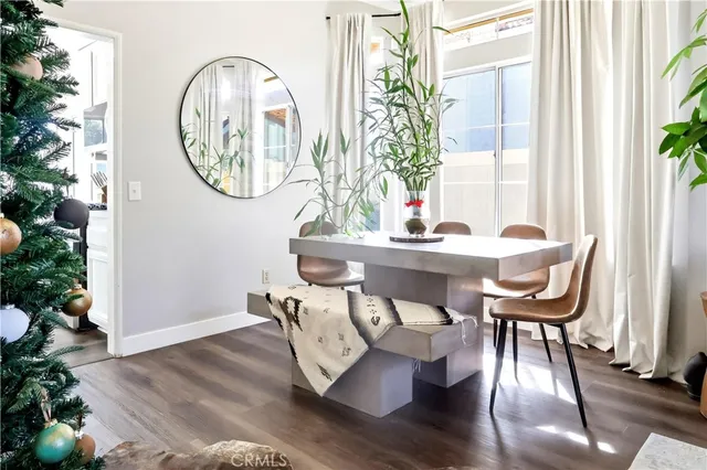a dining room with furniture a potted plant and wooden floor
