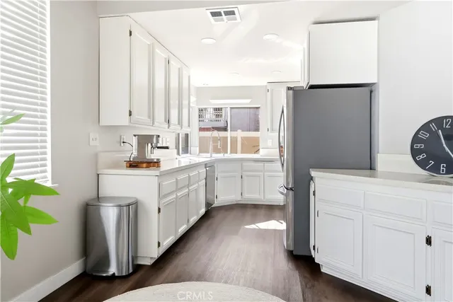 a kitchen with a white cabinets and window