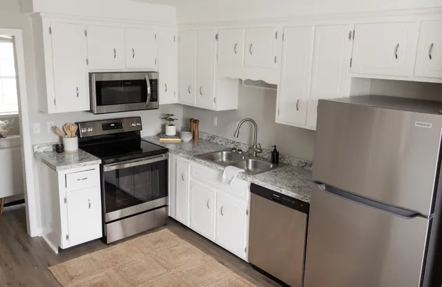 a kitchen with white cabinets and white appliances