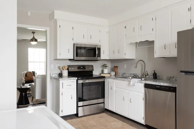 a kitchen with cabinets stainless steel appliances and a counter space