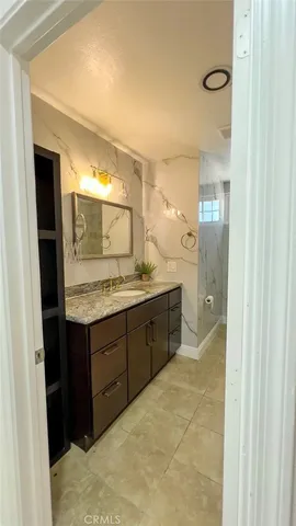 a bathroom with a granite countertop sink and a mirror