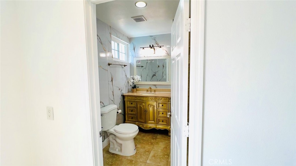 900 South Hayward Street Anaheim, CA 92804 - Photo 20 of 38 a bathroom with a granite countertop toilet and a sink