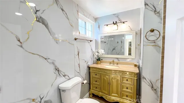 a bathroom with a sink vanity mirror and toilet