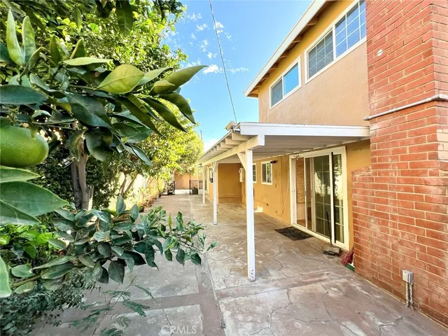 a front view of a house with a tree