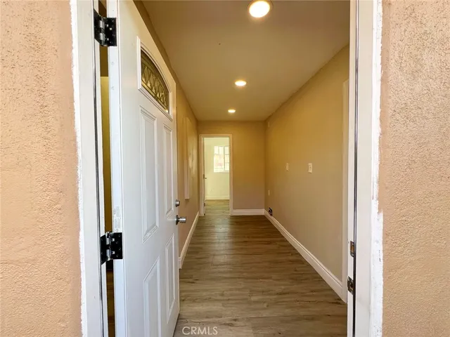 a view of an empty room with wooden floor