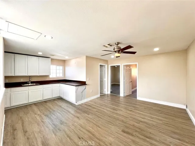 a view of empty room with wooden floor and window