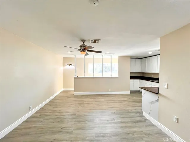 a kitchen with granite countertop white cabinets and wooden floor