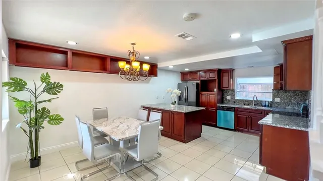 a kitchen with stainless steel appliances granite countertop a sink and a refrigerator