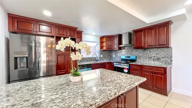 a kitchen with stainless steel appliances granite countertop a refrigerator sink and cabinets